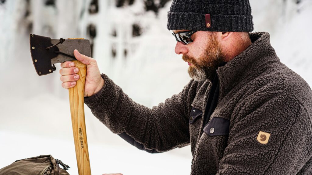 Rugged Outdoorsman with Hults Bruk Axe in Snowy Landscape 4K Wallpaper