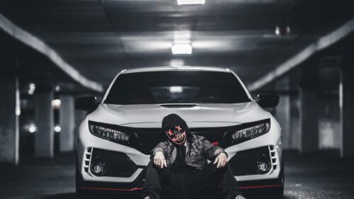 Edgy Hooded Figure with Glowing Mask in Front of Honda Civic Type R 4K Wallpaper