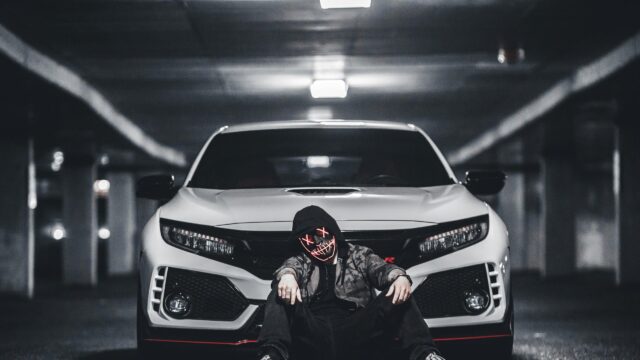 Edgy Hooded Figure with Glowing Mask in Front of Honda Civic Type R 4K Wallpaper