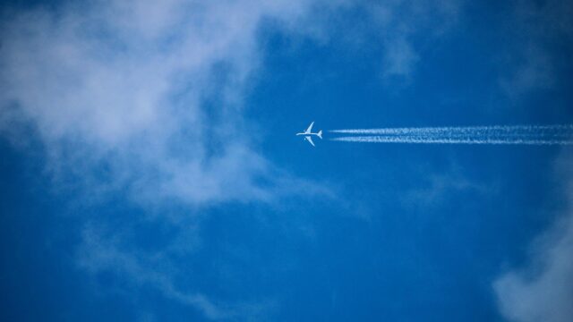 Airplane Soaring Through Blue Skies With Contrails PC Wallpaper