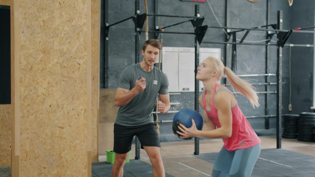 Personal Trainer Coaching Female Athlete in Gym 4K Wallpaper