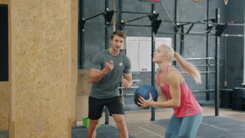 Personal Trainer Coaching Female Athlete in Gym 4K Wallpaper