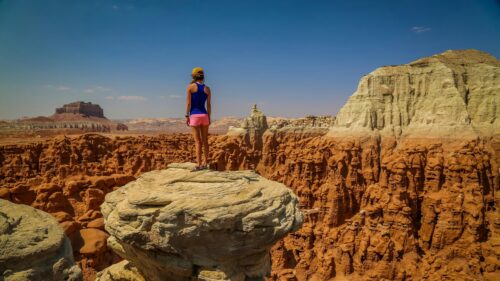 Explorer Standing on Hoodoo Rock Formation in Goblin Valley 4K Wallpaper