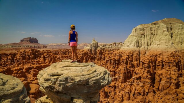 Explorer Standing on Hoodoo Rock Formation in Goblin Valley 4K Wallpaper