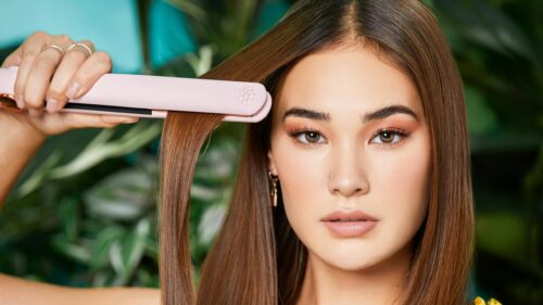 Beautiful Woman Styling Hair with Pink Straightener 4K Wallpaper