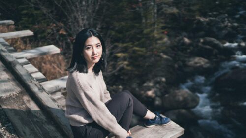 Asian Girl Sitting on Wooden Trailside Bench Desktop Wallpaper