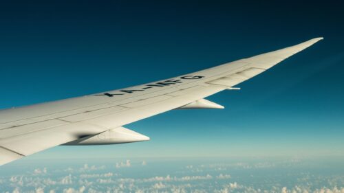 Stunning Aerial View of Airplane Wing Over Blue Sky Desktop Wallpaper