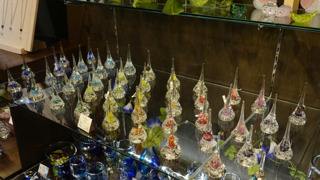 Crystal Glass Teardrop Figurines on Display Case 4K Wallpaper