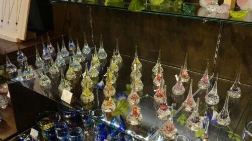 Crystal Glass Teardrop Figurines on Display Case 4K Wallpaper