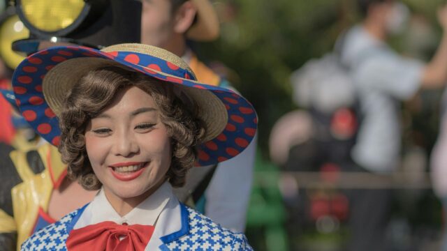 Smiling Performer in Polka Dot Hat Cosplay 4K Desktop Wallpaper