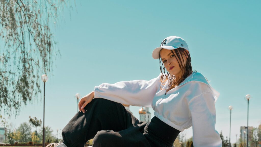 Stylish Young Woman in White Hoodie and Baseball Cap PC Wallpaper