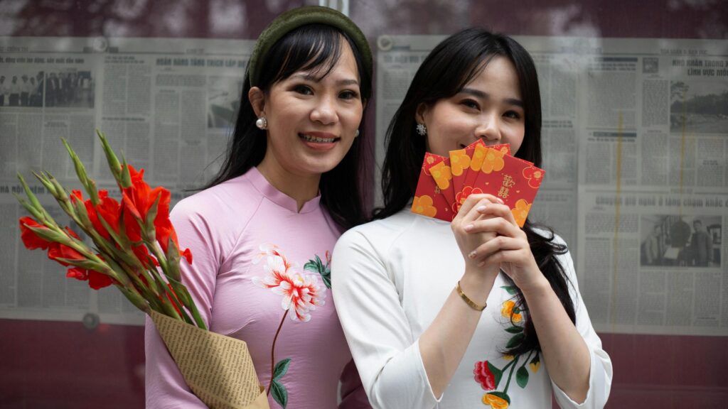 Two Asian Women in Traditional Ao Dai with Red Envelopes Desktop Wallpaper