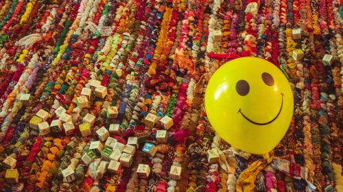 Happy Yellow Smiley Face Balloon on Colorful Rag Rug Desktop Wallpaper