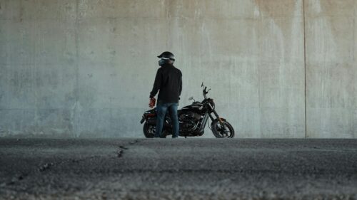 Biker with Black Harley Davidson Motorcycle Against Concrete Wall 4K Wallpaper