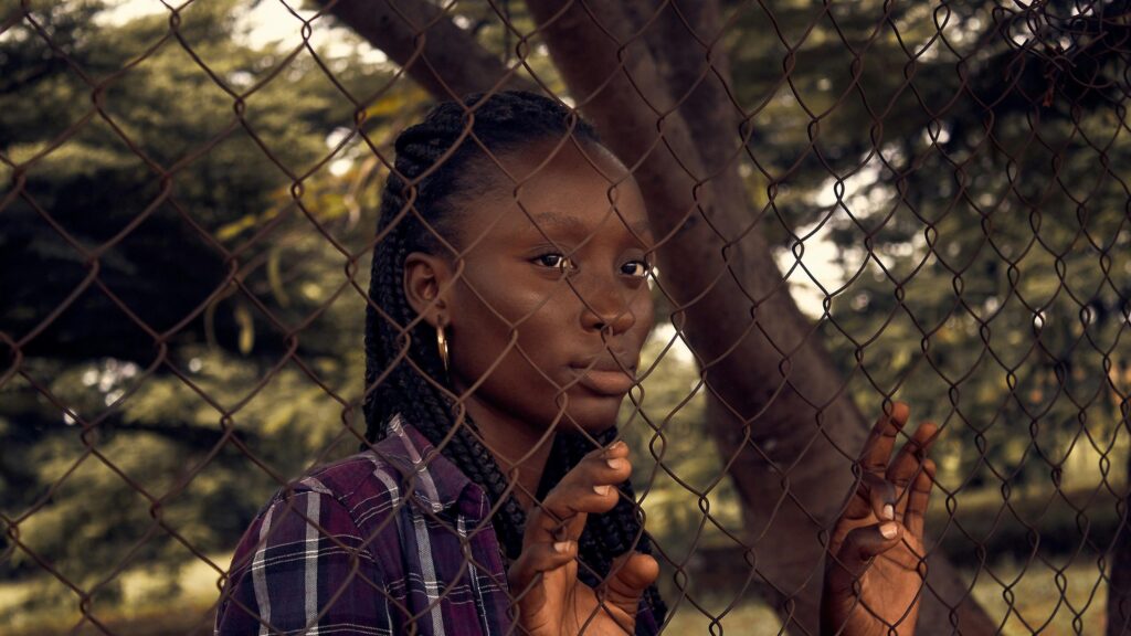 Young Woman Behind Chain Link Fence Moody Portrait 4K Wallpaper