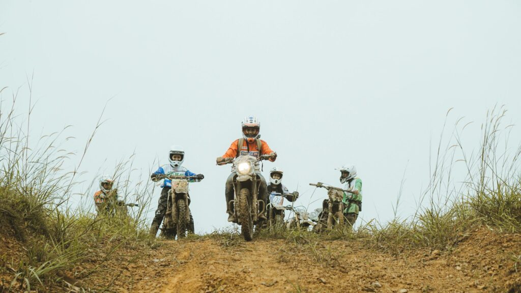 Group of Motocross Riders Ascending a Dirt Hill Desktop Wallpaper