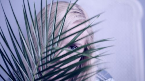 Blonde Woman Hidden Behind Tropical Palm Leaf PC Wallpaper