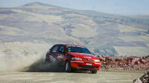 Red Rally Car Racing Through Dusty Landscape 4K Desktop Wallpaper