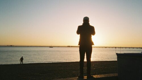 Man Watching Sunset Over Ocean Pier Desktop Wallpaper
