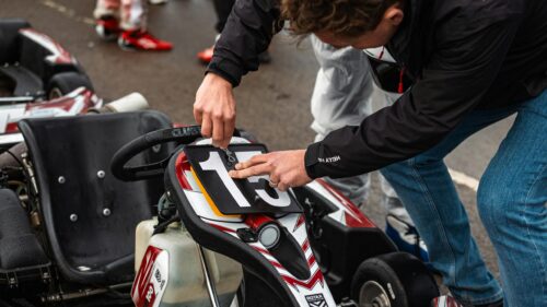 Close-up Mechanic Attaching Kart Number Plate Desktop Wallpaper