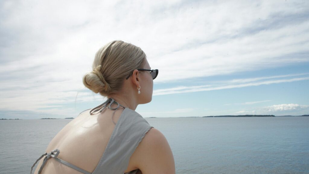 Woman Looking Out at the Calm Serene Ocean Horizon 4K Desktop Wallpaper