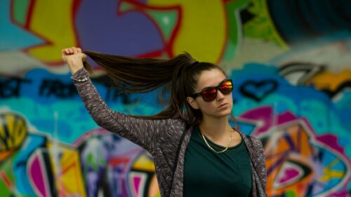 Stylish Girl With Sunglasses Against Vibrant Graffiti Wall 4K Wallpaper