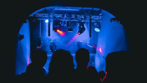 Concert Stage Crowd Silhouette with Vibrant Stage Lights 4K Wallpaper