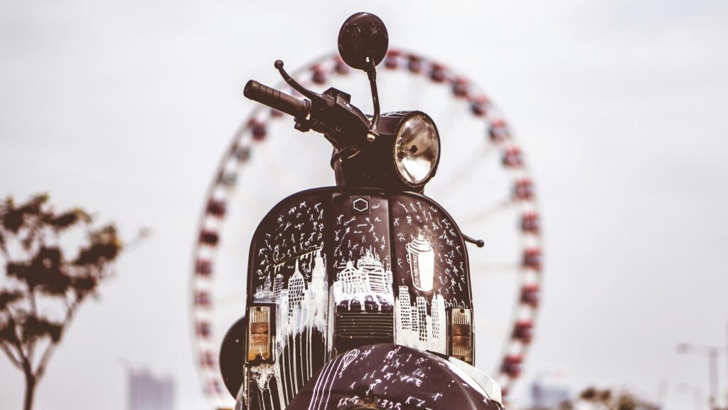 Black Scooter with White Street Art and Ferris Wheel Desktop Wallpaper