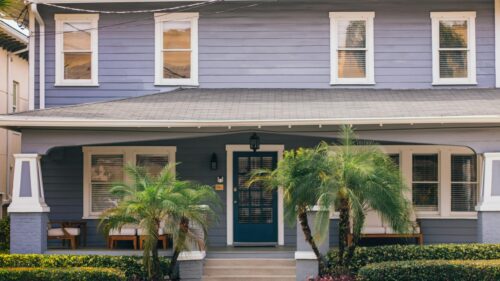 Charming Blue Suburban House Porch with Tropical Plants Desktop Wallpaper
