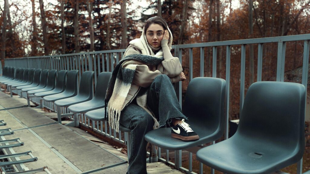 Woman Sitting on Stadium Seats in Autumn Park 4K Desktop Wallpaper