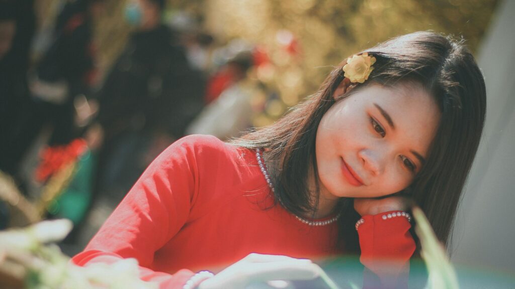 Beautiful Asian Girl in Red Ao Dai with Flower Hair Accessory 4K Wallpaper