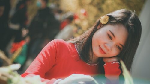 Beautiful Asian Girl in Red Ao Dai with Flower Hair Accessory 4K Wallpaper
