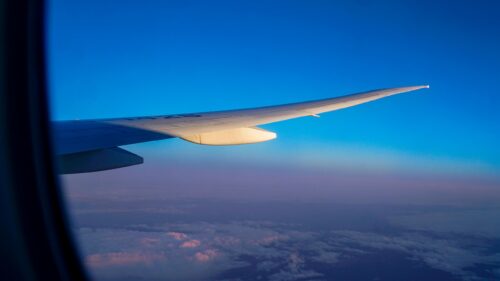 Stunning Airplane Wing at Sunset Above the Clouds 4K Wallpaper