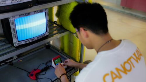 Gamer Playing Retro Handheld Console in Neon Studio 4K Wallpaper