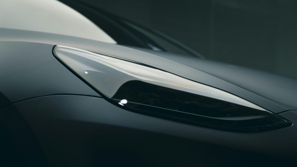 Sleek Matte Grey Supercar Headlight Close-Up 4K Wallpaper