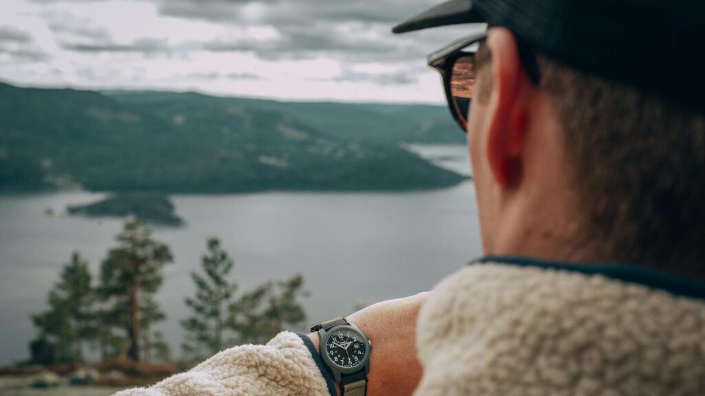 Adventurous Hiker Checking Timex Watch Over Lake View Desktop Wallpaper