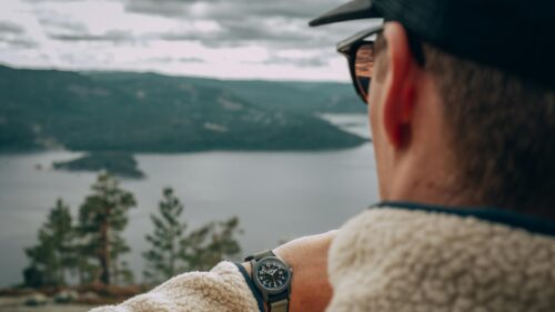 Adventurous Hiker Checking Timex Watch Over Lake View Desktop Wallpaper