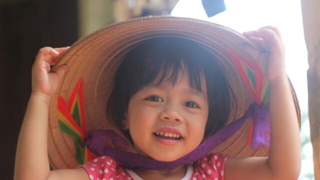 Happy Little Girl Wearing Traditional Conical Hat 4K Desktop Wallpaper
