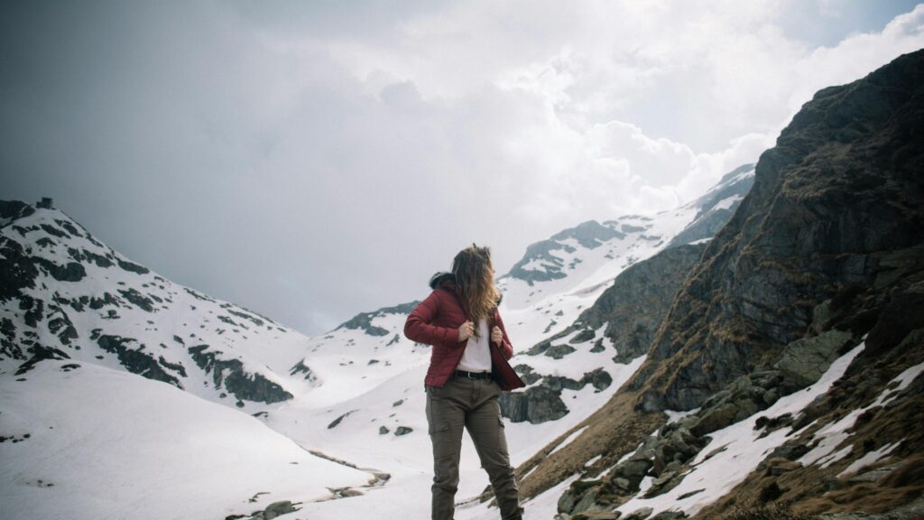Adventurous Woman in Snowy Mountain Landscape Desktop Wallpaper