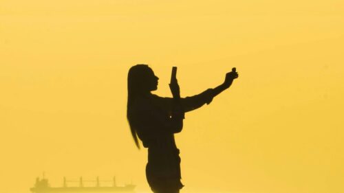 Silhouette of a Woman Taking a Sunset Selfie Desktop Wallpaper
