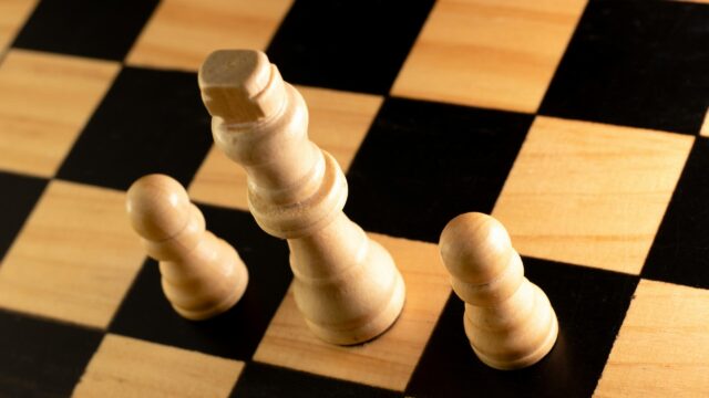 Minimalist White Chess King and Pawns on Wooden Board 4K Wallpaper