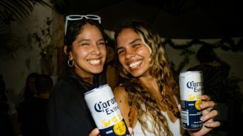 Two Happy Women Celebrating with Corona Beer at a Party Desktop Wallpaper