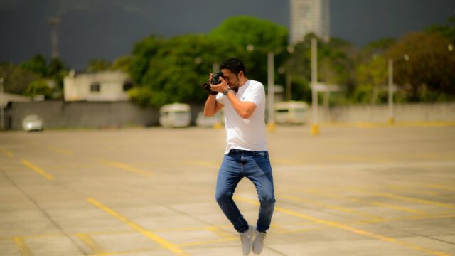 Photographer Jumping Mid-Air Action Shot 4K Wallpaper