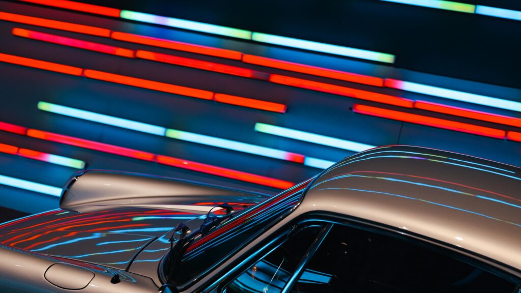 Classic Silver Porsche Sportscar Against Neon Light Trails 4K Wallpaper
