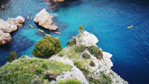 Aerial View of Kayakers in Turquoise Coastal Waters 4K Wallpaper