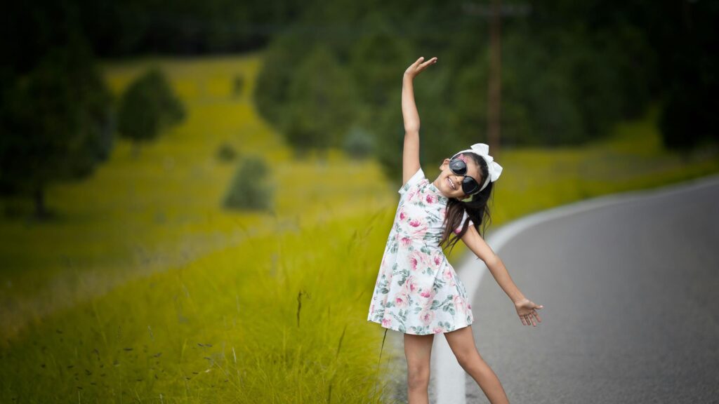 Happy Girl in Floral Dress Standing on Country Road Desktop Wallpaper