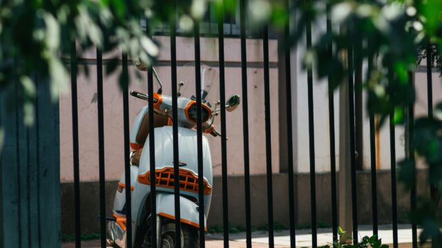 Vintage Style Scooter Behind Black Metal Fence Desktop Wallpaper