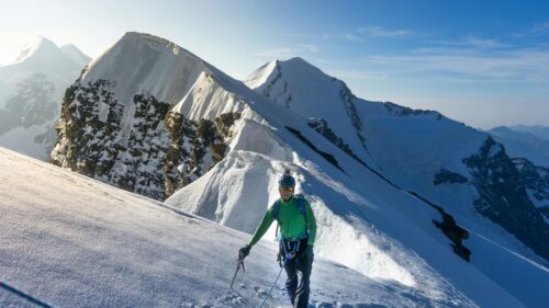 Climbing Adventurer on Snowy Alpine Ridge 4K Wallpaper
