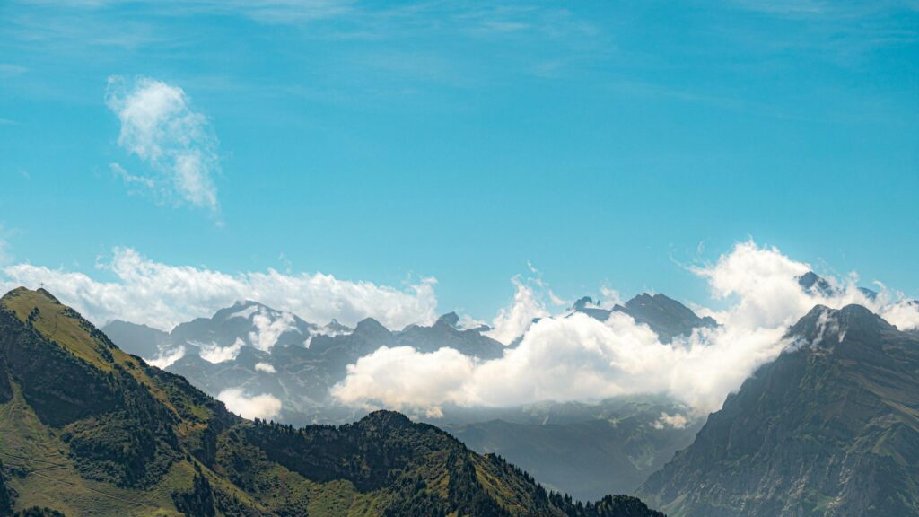 Stunning Alpine Peaks with Rolling Clouds Desktop Wallpaper