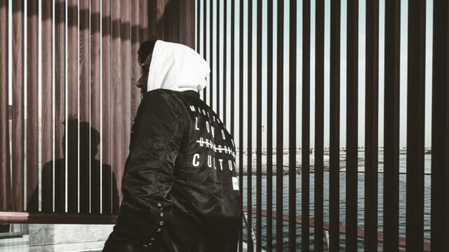 Urban Fashion Man in Black Jacket Standing by Waterfront PC Wallpaper